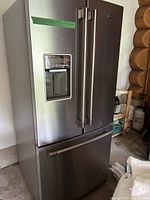 Front view of Maytag stainless steel French door refrigerator with bottom freezer in garage