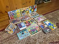 Photo showing entire assortment of children's puzzles and toy sets arranged on floor.