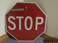 Full view of the metal stop sign showing the red octagonal shape, white border, and STOP lettering.