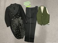 Front view of tuxedo components: tailcoat jacket, trousers, green vest laid flat showing style and materials