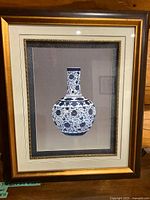 Framed embroidery artwork of a blue and white vase shown fully in its frame