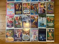 Overview of 20 VHS tapes arranged in 4 rows, titles visible including Disney classics and other family films.