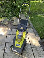 Front view showing handle, deck, and attached grass catcher bag