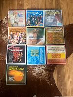 Top view of 9 boxed vinyl record sets arranged on a wooden floor showing artwork and titles.