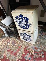 Stacked Royal Crest Dairy wooden milk boxes with visible logos and wear.