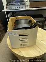 Image showing a box holding the cast iron items, some handles visible inside the box.