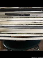 Top-down view of spines of various luxury and automotive magazines in bankers box, showing titles and dates including Land Rover Monthly December 2017, Persiche Panorama, and exclusive Hagerty Drivers Club publications.