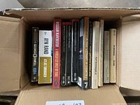 Top view inside box showing a row of softcover novels including 1984 by George Orwell, Atlas Shrugged by Ayn Rand, and others.