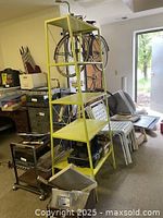 Photo of the tall yellow shelving unit in a room environment showing overall structure, color, and items stored on shelves.