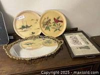 Overview of the lot showing two large round fiberglass trays with bird designs, a large ornate mirrored tray, smaller fiberglass trays, and a rectangular McCalls magazine tray on top of a wooden surface.