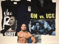 Three folded vintage WWF T-shirts showing wrestler graphics and text.