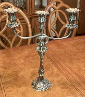 Full view of silver plated Art Nouveau candelabra with three arms and ornate detailing.
