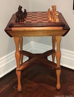 Full front view of square wooden chess table with chess pieces on board
