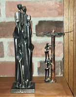 Front view of abstract metal sculpture showing full height and figure grouping