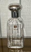 Front view of the Carlo Moretti clear ribbed glass decanter with silver-tone stopper in place and original label visible on the body.
