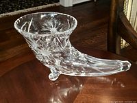 Photo of cut crystal horn of plenty vase from side angle showing flared opening and cut patterns