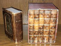 Antique Judaica prayer books set with one smaller embossed prayer book and a slipcase holding five volumes.