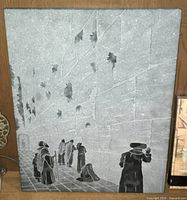 Front view of the carved stone plaque showing the Wailing Wall and six carved figures praying along it.