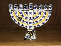 Full view of the vintage Canadian studio pottery menorah decorated with blue flowers, yellow designs, and bees.