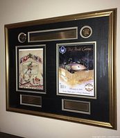Full view of framed commemorative piece showing programmes, medallions, plaques in gold-tone frame