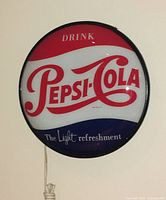 Front view of round convex glass light with Pepsi-Cola logo