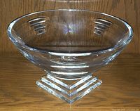 Clear Waterford crystal footed bowl with geometric rectangular etched patterns around rim and layered square base on wooden surface.