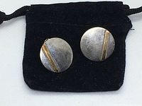 Two round disc earrings on black velvet pouch, front view showing full pair