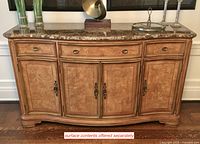 Front view of curved three-drawer, four-door sideboard with marble top