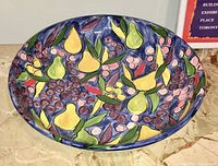 Top-down photo showing interior vibrant hand-painted fruit design on charger bowl