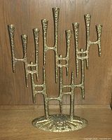 Front view of full menorah showing all nine candle holders and base