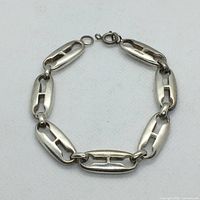 Top view of the bracelet showing all seven large hollow links connected by smaller round links and the spring ring clasp.