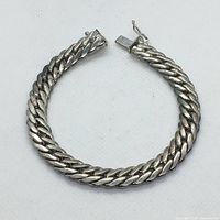 Full view of the braided link bracelet laid in an open circle