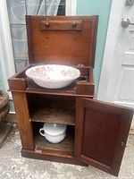 Full view of the wooden antique washing stand with open lid showing porcelain bowl.