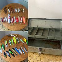 Top-down view showing 31 assorted fishing lures placed on a wooden round table surface, and interior of the open metal tackle box showing rust and wear.