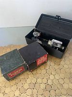 Four vintage fishing reels shown, ABU 505 box in foreground with reels stored inside a black plastic box
