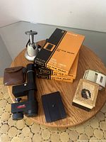 Lot of vintage camera accessories including camera holders, prism finder, ball head, light reader and slide viewer.