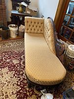 Full view of chaise lounge showing shape, upholstery and carving