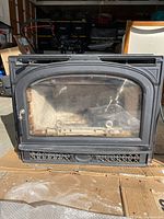 Front view of fireplace insert with glass door and trim