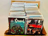 View from above showing two stacks of comic books with The Creech and Hellblazer as front covers.