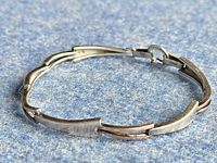 Full view of the vintage Taxco bracelet laid flat to show links and clasp indicating material contrast.