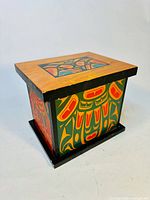 Front angle view showing the wood box with Aboriginal art on the sides and lid.