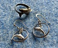 Ring and earrings displayed on blue fabric background showing design detail.