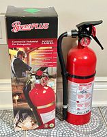 Pyrene Plus fire extinguisher shown next to its original retail box with product labels and branding visible.