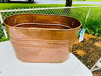 Front and side view showing copper boiler with oval shape and original galvanized handles attached.