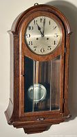 Front view of Junghans Eastlake style regulator clock showing dial, pendulum, and wood case details.