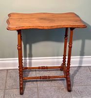 Full view of the antique maple wood table showing scalloped edge top and spool turned legs