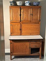 Full front view of the Hoosier cupboard showing upper and lower sections, doors, drawers, countertop and open cubby.