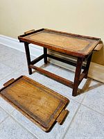 Side table and complementary wooden tray placed on tiled floor against a wall.