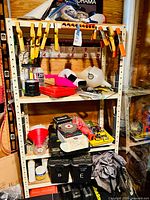 Full view of shelving unit with clamps attached, red toolbox, funnels, and bins visible