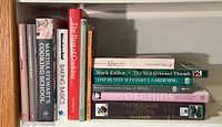 Shelf with assorted cookbooks and gardening books, showing titles like Martha Stewart's Cooking School and Step by Step Successful Gardening.